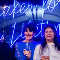 President Mantella smiles with a grad in front of the Laker for a Lifetime sign
